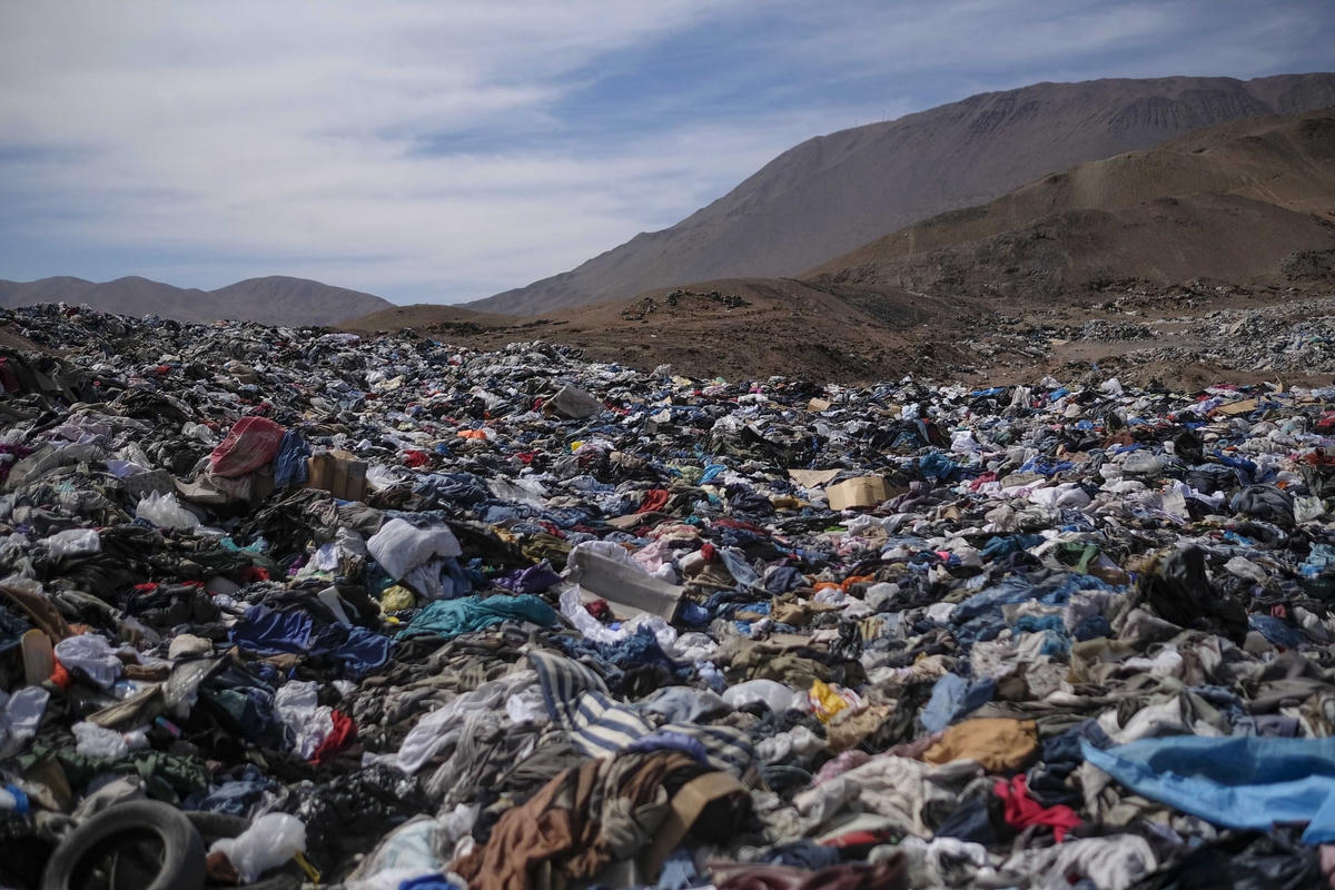 Một đống lớn quần áo cũ phủ đầy cát gần khu phố La Mula ở thành phố tự trị Alto Hospicio. Chile là nước nhập khẩu quần áo cũ lớn và những mặt hàng không bán được đều được bán phá giá ở đây. Ảnh: The Guardian.