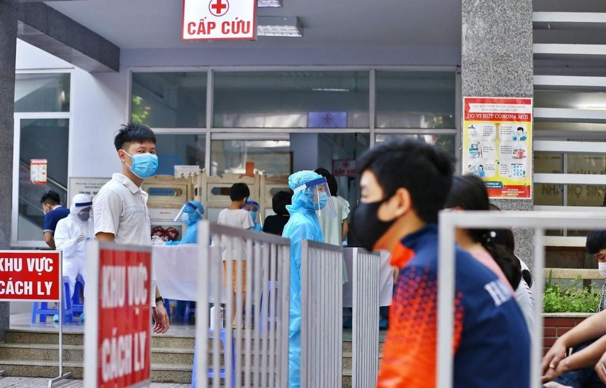 Người dân đến lấy mẫu được bố trí ngồi chờ theo khu vực quy định. Ảnh: TTXVN.