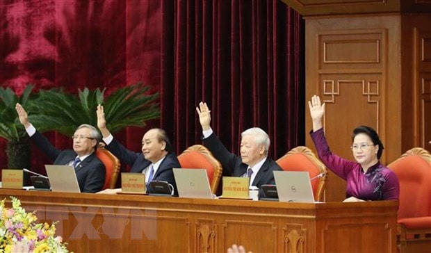 Các đồng chí lãnh đạo Đảng, Nhà nước biểu quyết thông qua Nghị quyết Hội nghị. Ảnh: TTXVN.