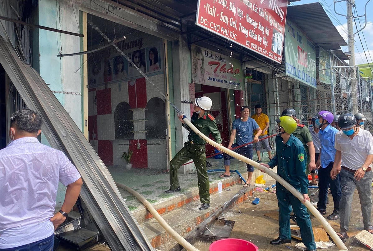Lực lượng chức năng khẩn trưa dập lửa tại chợ huyện Phú Túc.