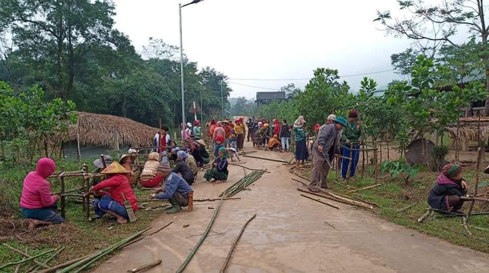 Người dân xã Minh Hóa tham gia trồng đường hoa kiểu mẫu ở bản làng.