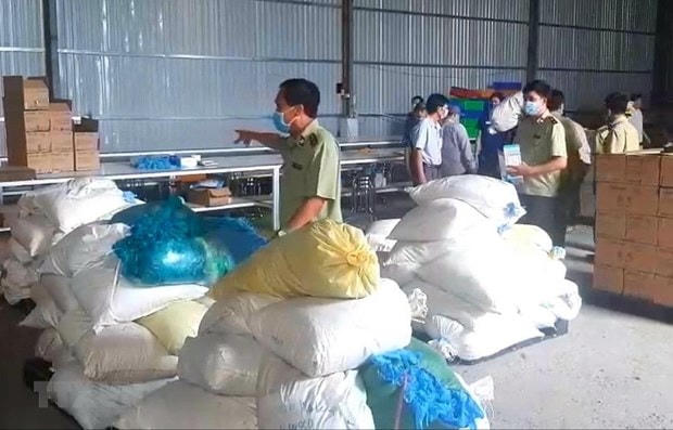 Kho chứa hàng găng tay y tế không đảm bảo chất lượng bị cơ quan chức năng phát hiện. (Ảnh: Huyền Trang/TTXVN).