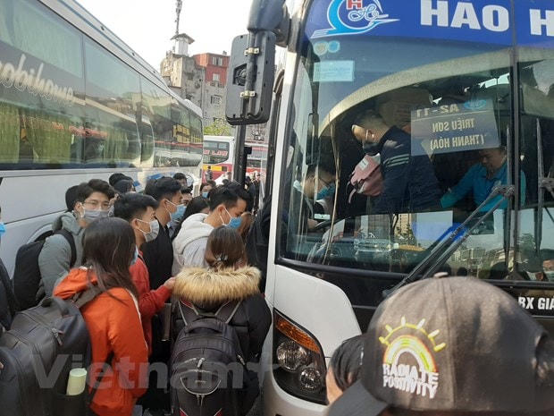 Ai cũng mong muốn lên xe sớm để tìm được chỗ ngồi tốt và nhanh được về nhà nghỉ Tết Dương lịch. (Ảnh: Việt Hùng/Vietnam+).