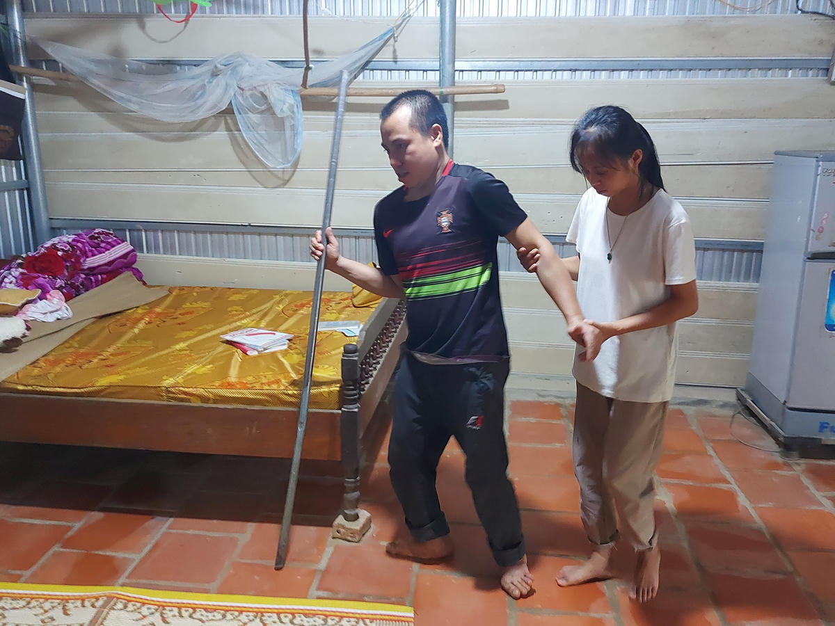 Chân và tay anh Dũng bị co quắp, bởi vậy đi lại rất khó khăn.