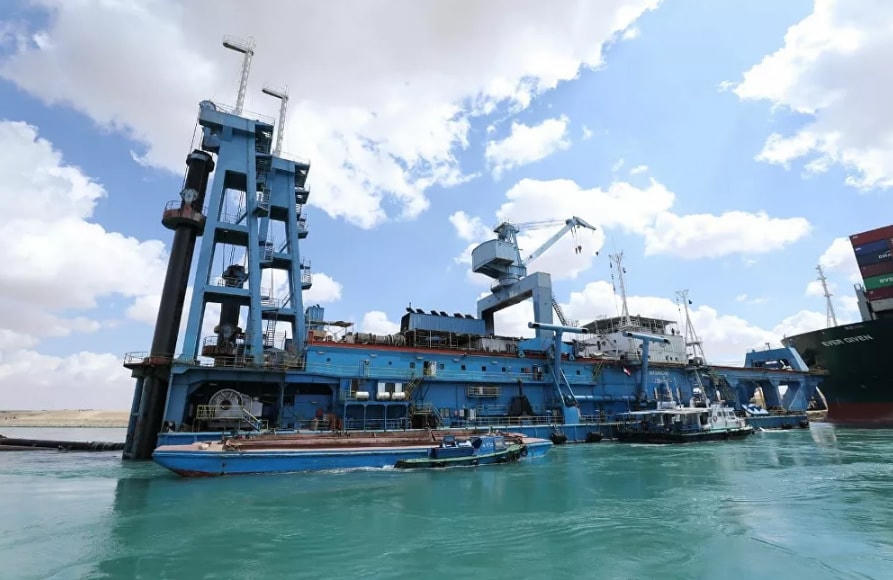 Một tàu cuốc cố gắng giải thoát tàu container Ever Given bị mắc cạn ở kênh đào Suez, Ai Cập.