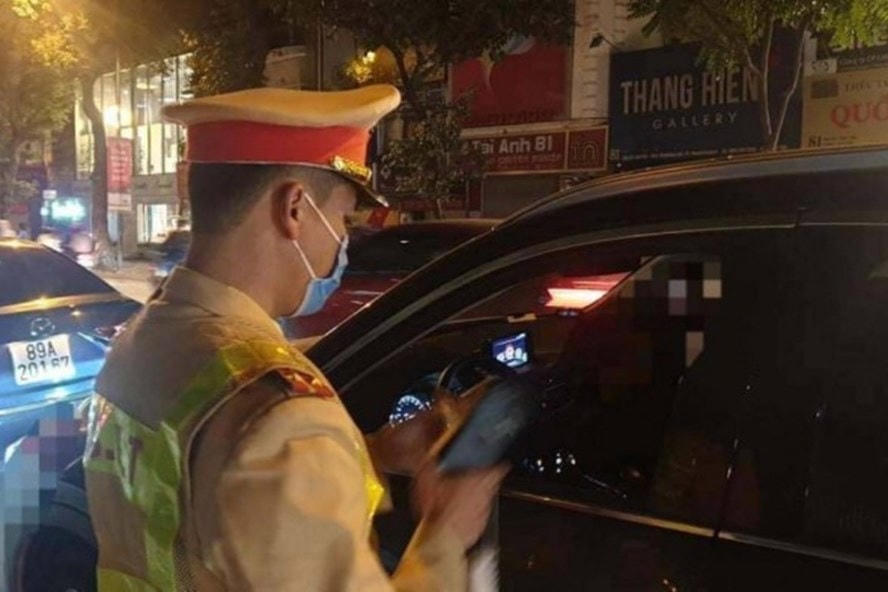 Cảnh sát giao thông đo nồng độ cồn với nữ tài xế lái xe Camry. Ảnh: Công an cung cấp.