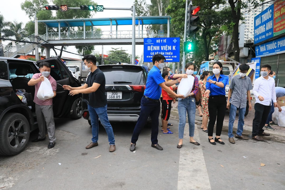 Chương trình “Cơm cho người nghèo trong đại dịch Covid-19” của Báo Đại Đoàn Kết chuyển những túi quà đến điểm hỗ trợ. Ảnh: Quang Vinh.