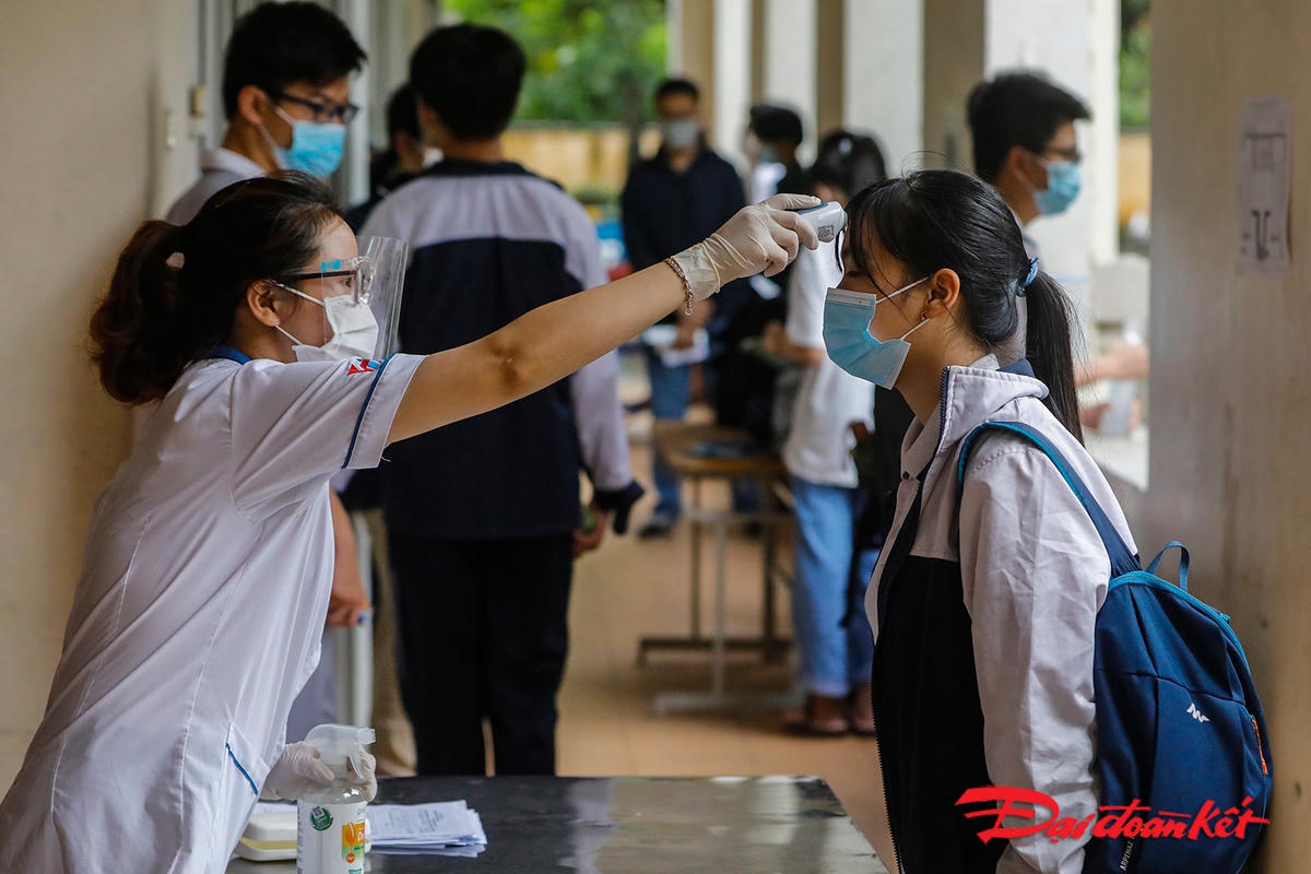 Các thí sinh được đo thân nhiệt và bắt buộc khai báo y tế trước khi vào phòng thi.
