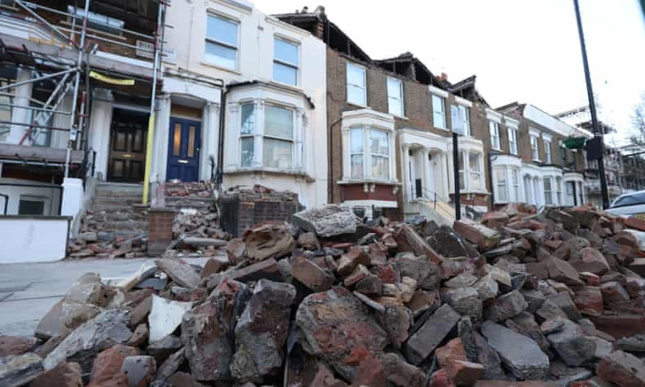 Vỉa hè phủ đầy những mảnh gạch vỡ từ loạt căn nhà tại London, Anh. Ảnh: The Guardian.