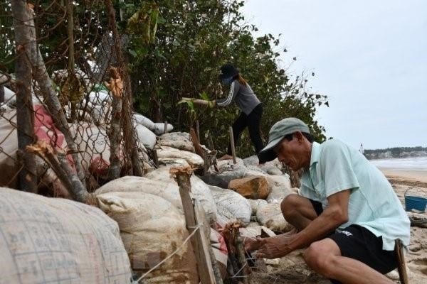 Người dân tham gia chằng chống khu vực ven biển trước bão số 9. (Ảnh: TTXVN).