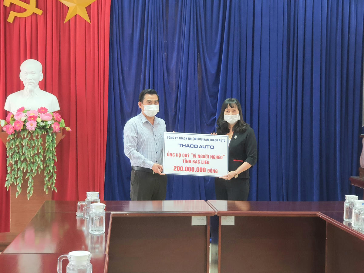 Trao bảng tượng trưng 200 triệu đồng cho Quỹ “Vì người nghèo”.