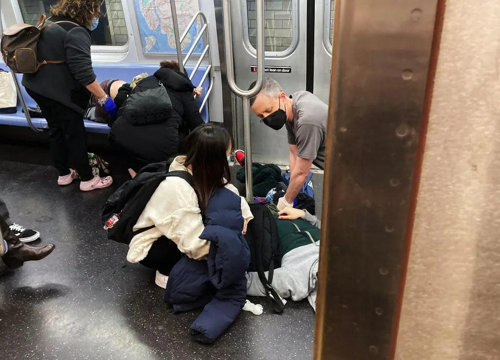 Hành khách chung tay sơ cứu cho những người bị thương trong vụ xả súng đẫm máu. Ảnh: AFP.