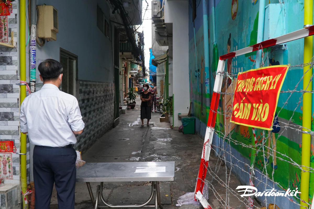 Tại đểm phong tỏa chứ 2, Ông Lê Tấi Tài đứng từ xa, nói chyện với người dân khu cách ly.