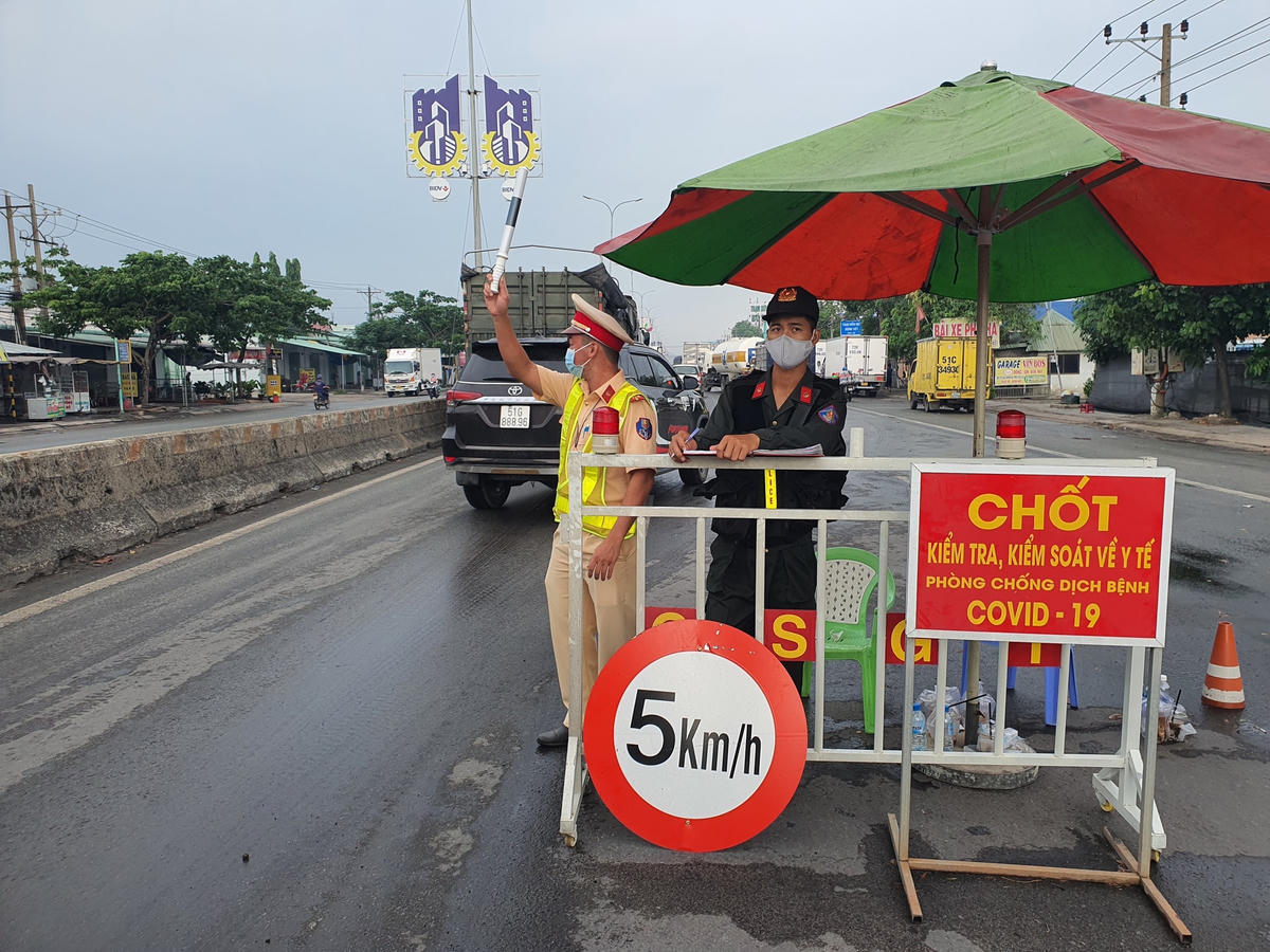 Lực lượng cảnh sát làm nhiệm vụ tại chốt kiểm tra, kiểm soát y tế trên quốc lộ 51. Ảnh: Hữu Vinh