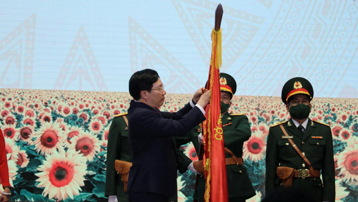 Phó Thủ tướng Thường trực Phạm Bình Minh gắn Huân chương Độc lập hạng Nhì lên Cờ truyền thống của huyện Lộc Ninh.