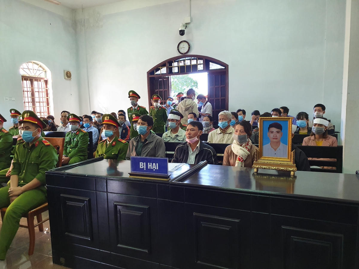 Gia đình bị hại đeo tang và mang di ảnh anh Lê Nho Vương đến phiên tòa.