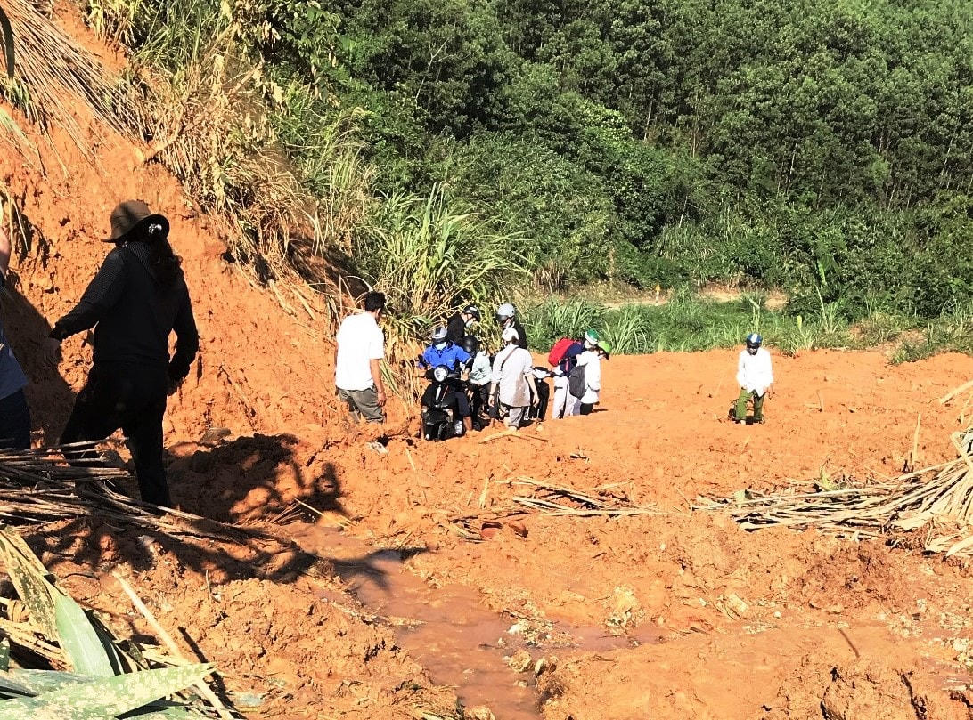 Cô Trang và người dân xã Trà Leng đi lại khó khăn trên con đường sạt lở.