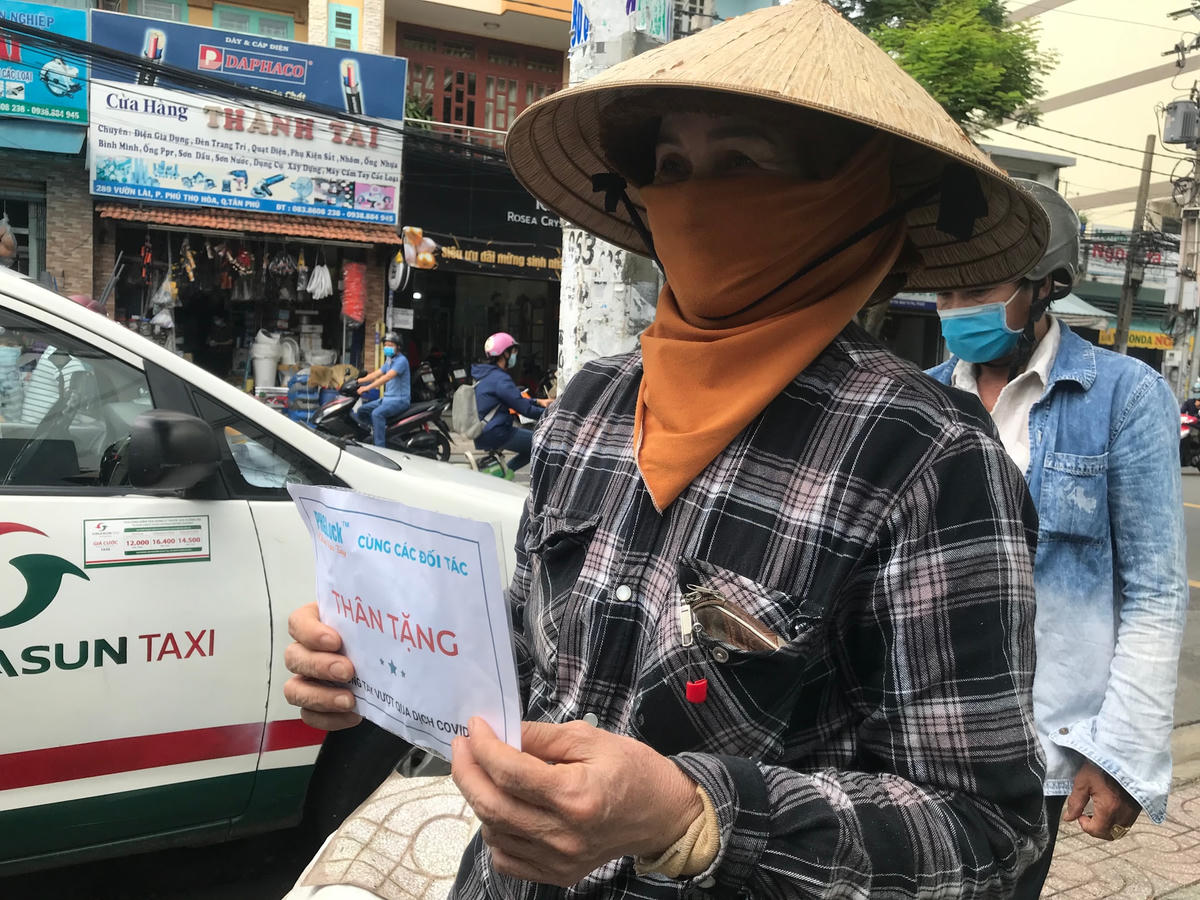 Nhiều người nghèo tới nhận khẩu trang. Ảnh: Đoàn Xá.