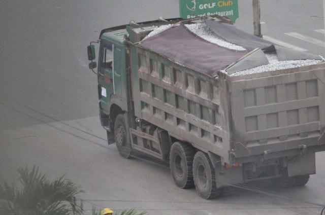 Những chiếc xe chở quá tải chỉ phủ bạt kiểu chống đối nên mỗi lần sa vào ổ gà, đất, đá, lại thi nhau rơi xuống đường.