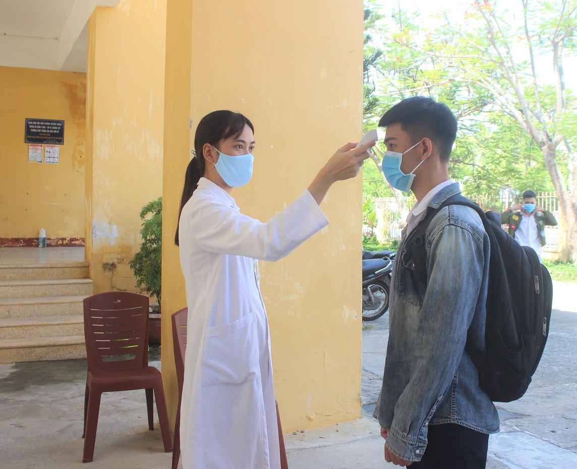 Nhân viên y tế đo thân nhiệt cho các thí sinh.