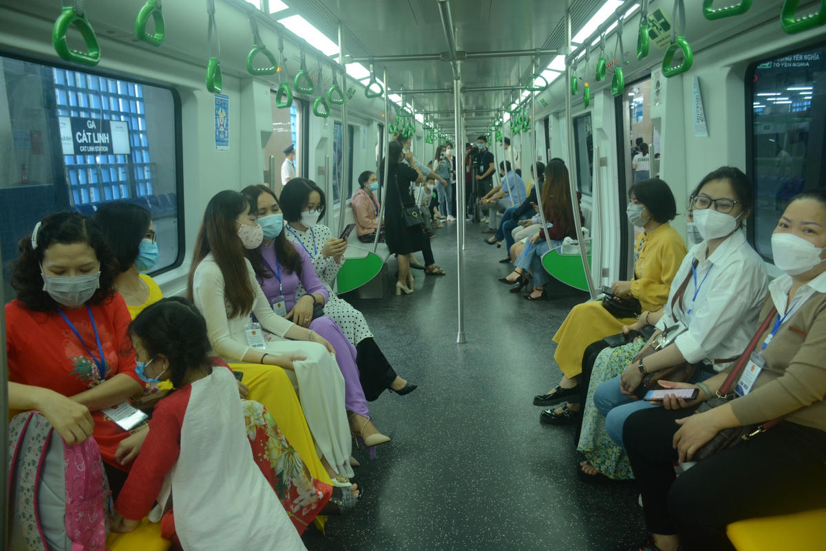 Nhiều hành khách mặc áo dài chào đón chuyến tàu đường sắt đô thị Cát Linh – Hà Đông.