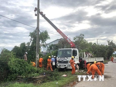 Công ty Điện lực Thừa Thiên-Huế khắc phục sự cố do mưa bão. (Ảnh: TTXVN phát).