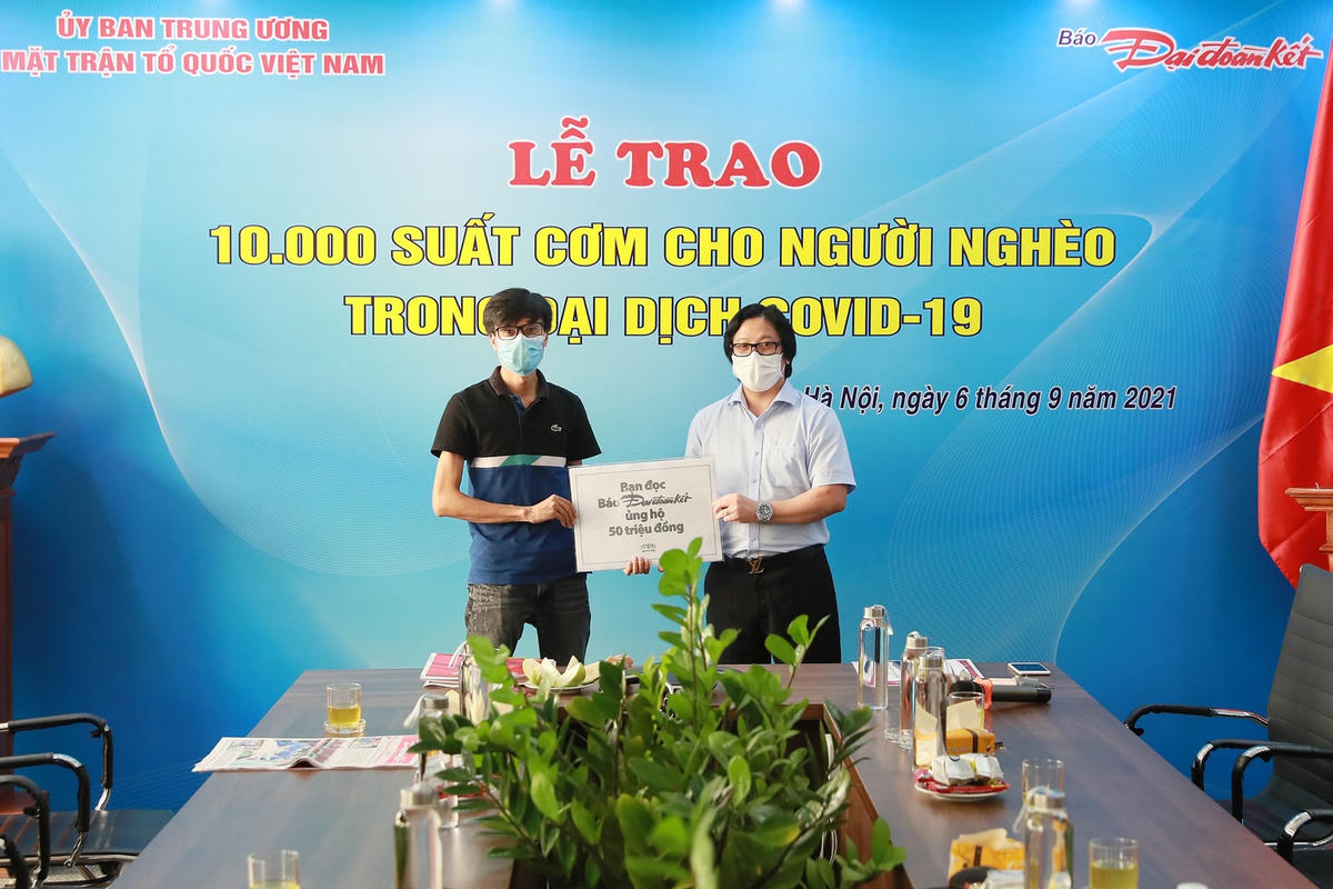 Quyền Tổng Biên tập Lê Anh Đạt nhận bảng tượng trưng tiền hỗ trợ chương trình từ bạn đọc báo Đại Đoàn Kết. Ảnh: Quang Vinh.