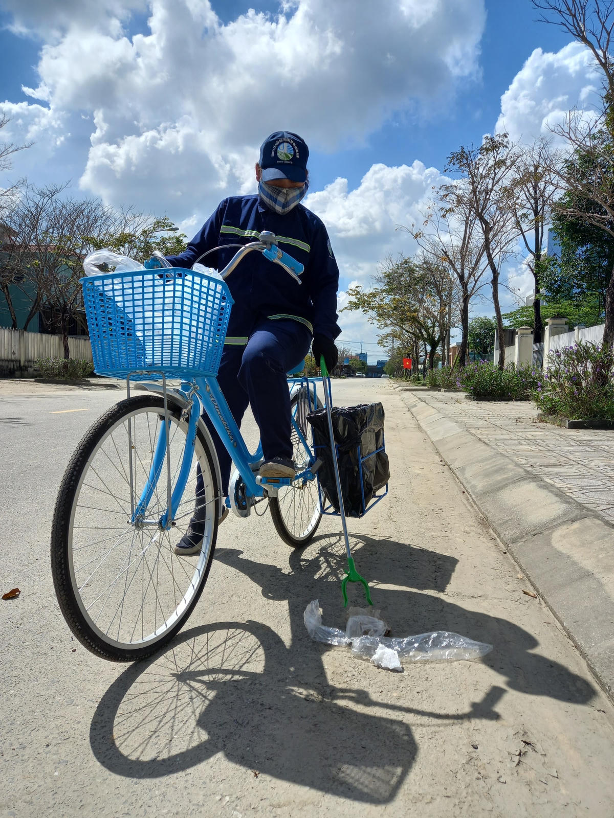 Một nữ công nhân đang thu gom rác trên phố.
