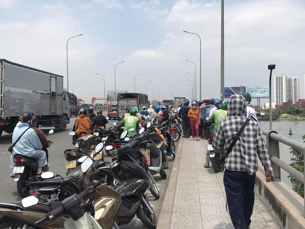 Người dân hiếu kỳ xem một xác người cháy đen dưới gầm cầu. Ảnh: TL