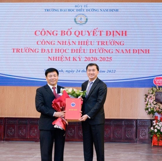 Thứ trưởng Bộ Y tế Trần Văn Thuấn trao quyết định công nhận cho ông Trương Tuấn Anh (trái).
