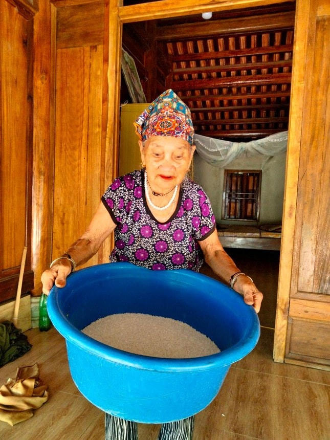 Cụ Vi Thị Mão đưa chậu gạo nặng 10kg đến tay cán bộ Mặt trận để ủng hộ chống dịch.