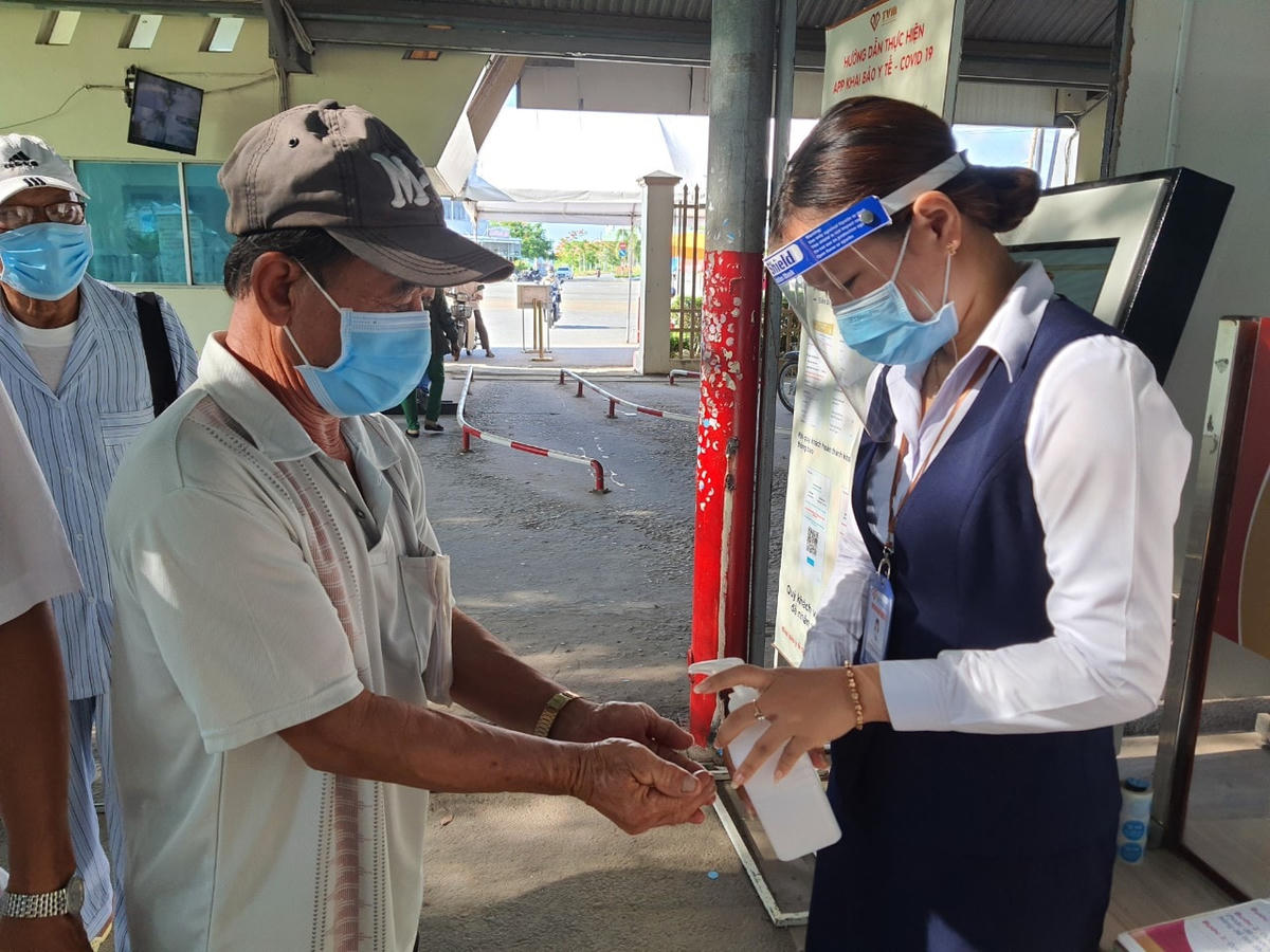 Người dân được rửa tay sát khuẩn trước khi vào cổng bệnh viện.