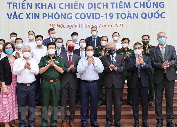 Thủ tướng Phạm Minh Chính và đại biểu, đại diện các tổ chức quốc tế tham dự Lễ phát động triển khai Chiến dịch tiêm chủng vaccine phòng Covid-19 toàn quốc. (Ảnh: Dương Giang/TTXVN).
