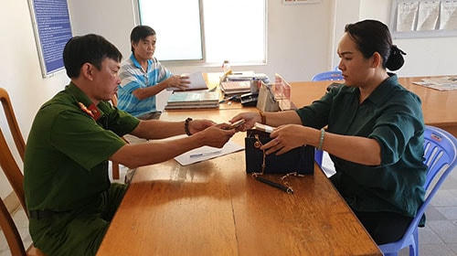 Chị Trần Thị Minh Trúc giao số tiền nhặt được cho cơ quan Công an phường Hưng Long, TP Phan Thiết.   