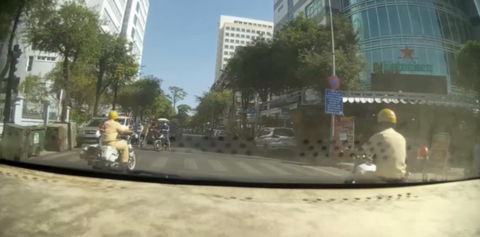 Hai cán bộ đội CSGT-TT Công an Q.5 dẫn đường cho TX đưa vợ chồng thai phụ tới BV - Ảnh cắt từ clip.