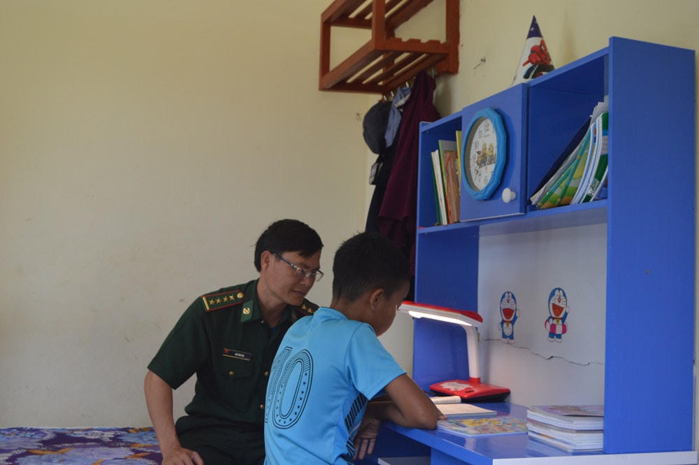 Chiến sĩ Đồn Biên phòng Cà Xèng hướng dẫn các em học tập.