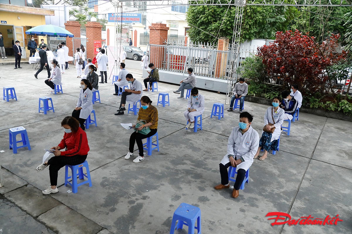 Những người được tiêm xếp hàng chờ đến lượt vào khám sức khỏe để đủ điều kiện tiêm phòng dịch.