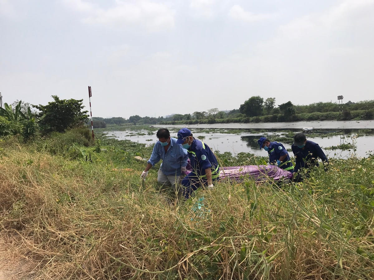Lực lượng chức năng vướt thi thể lên bờ và đưa đi khám nghiệm. Ảnh: TL.