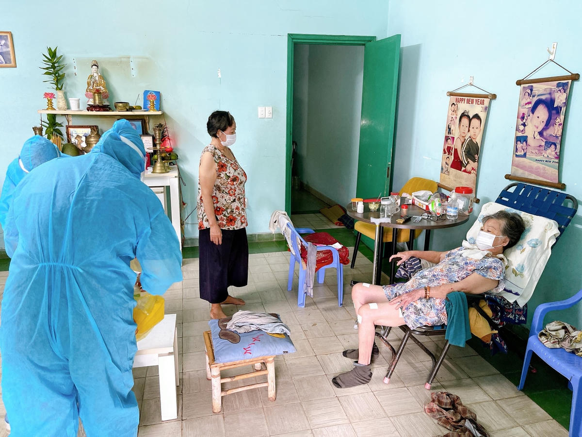 Nhân viên y tế chăm sóc F0 cách ly và điều trị tại nhà.