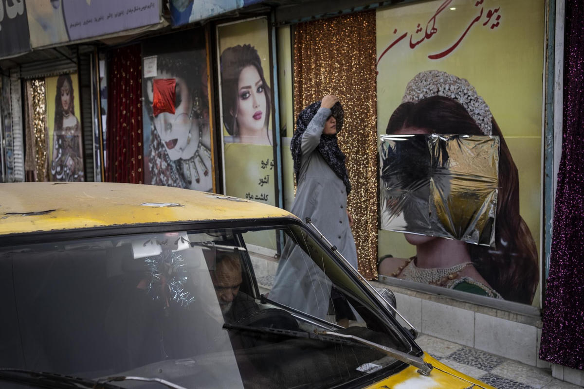 Người phụ nữ đi ngang qua một thẩm mỹ viện ở thủ đô Kabul, Afghanistan (12/9/2021). Ảnh: AP.