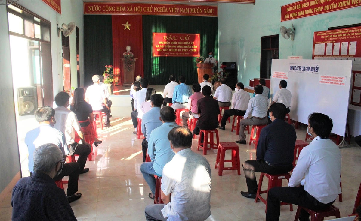Các cử tri ngồi giãn cách chờ đến lượt mình lên bỏ phiếu.