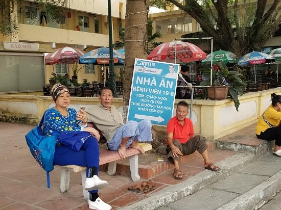 Nhiều bệnh nhân cùng người nhà tập trung tại ghế đá dưới sân Bệnh viện 198 mà không đeo khẩu trang để phòng dịch