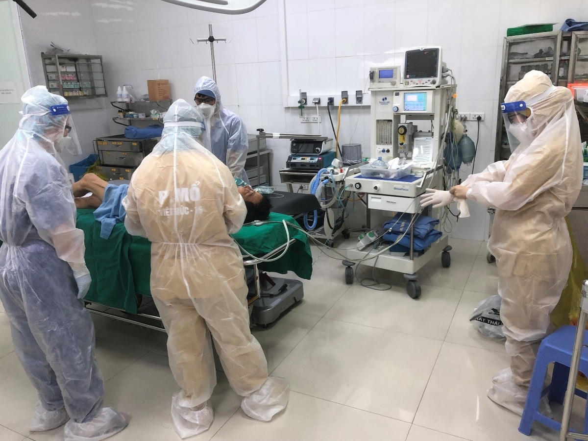 Các bác sĩ Bệnh viện Việt Đức chuẩn bị gây mê cho bệnh nhân N.V.Q mắc Covid-19. Cơ sở này dần bình thường hóa hoạt động chuyên môn chăm sóc điều trị phẫu thuật người bệnh nhiễm Covid-19. Ảnh: SKĐS.