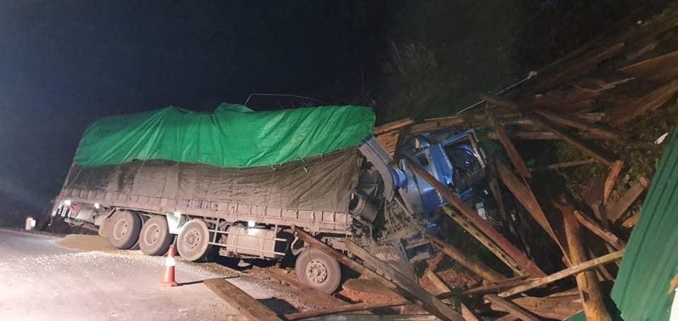 Chiếc xe tải chở gỗ lao vào vách núi, phần cabin bị biến dạng.