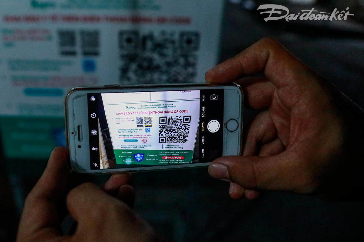 Tại cổng có đặt bảng QR code và hướng dẫn để mọi người khai báo y tế trước khi vào chợ.