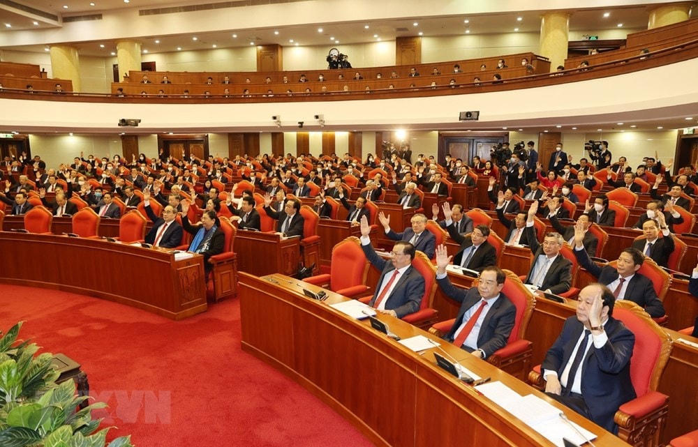 Các đồng chí lãnh đạo Đảng, Nhà nước và các đại biểu biểu quyết thông qua chương trình Hội nghị. (Ảnh: Trí Dũng/TTXVN).