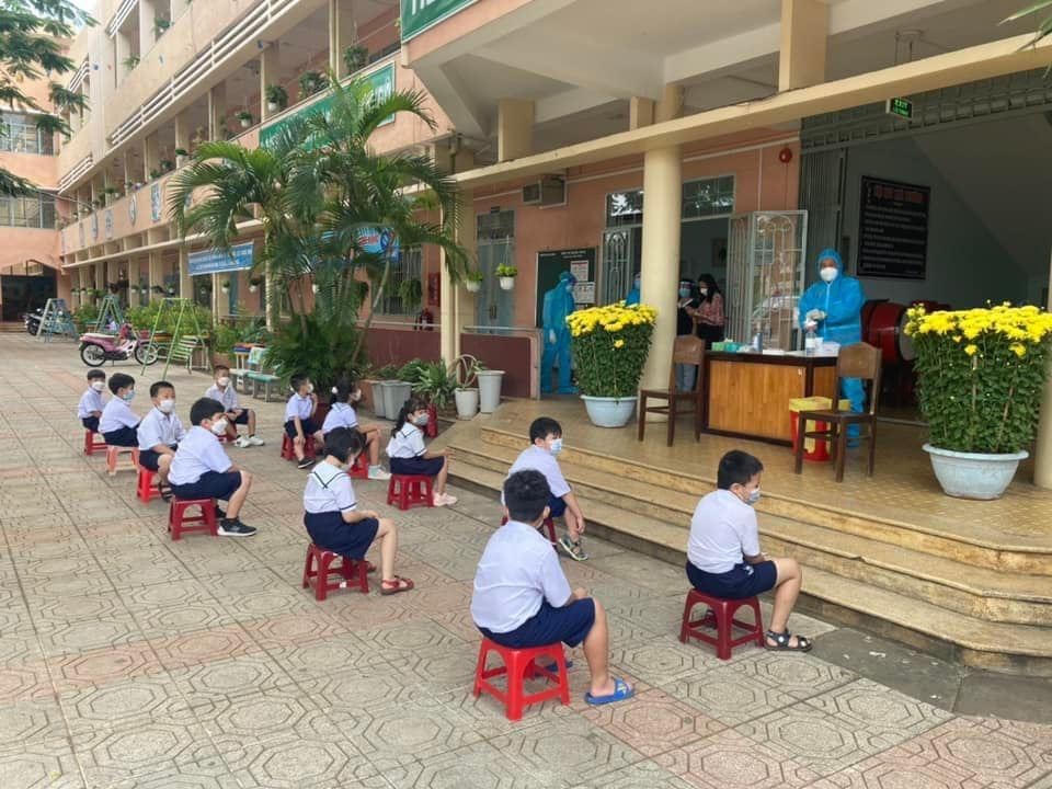 Học sinh một trường tiểu học ở Đồng Nai chờ test nhanh Covid-19 trước khi vào lớp.