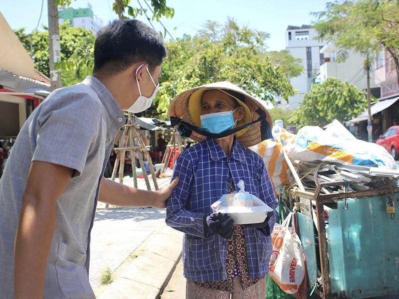 Bà Hồng xúc động đón nhận suất ăn từ thầy giáo Trương Vĩnh Đặng. Ảnh: PLO.