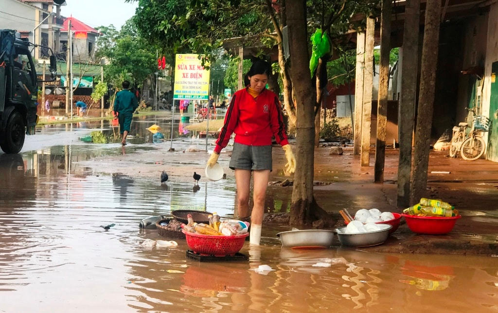 Người dân xã Cẩm Mỹ phải rửa bát đũa bằng nước lũ đọng lại bên đường.