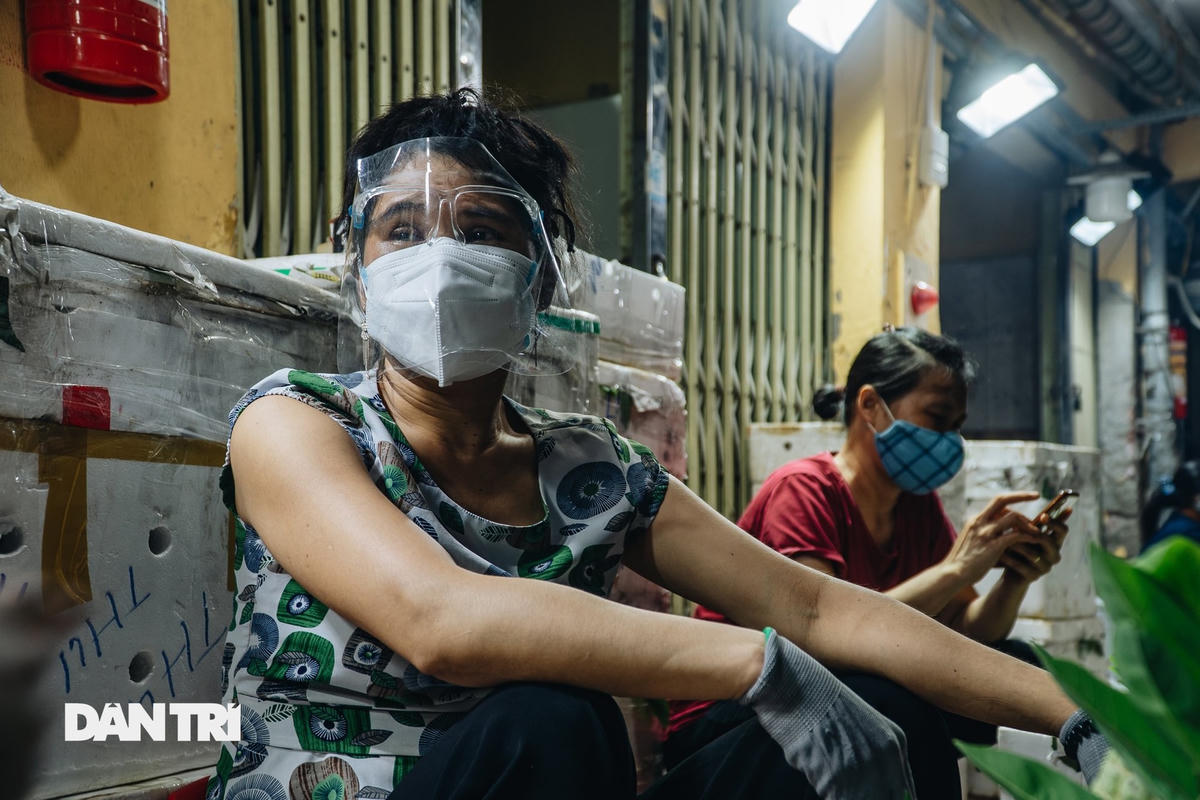 Một nữ tiểu thương cẩn thận trang bị khẩu trang, kính chắn giọt bắn để phòng dịch. Nguồn Dân Trí.